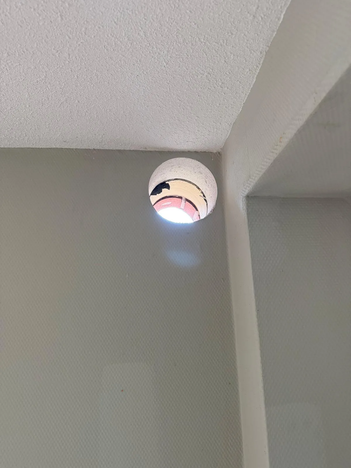 Afzuigkap gat geboord in witte muur plafond hoek