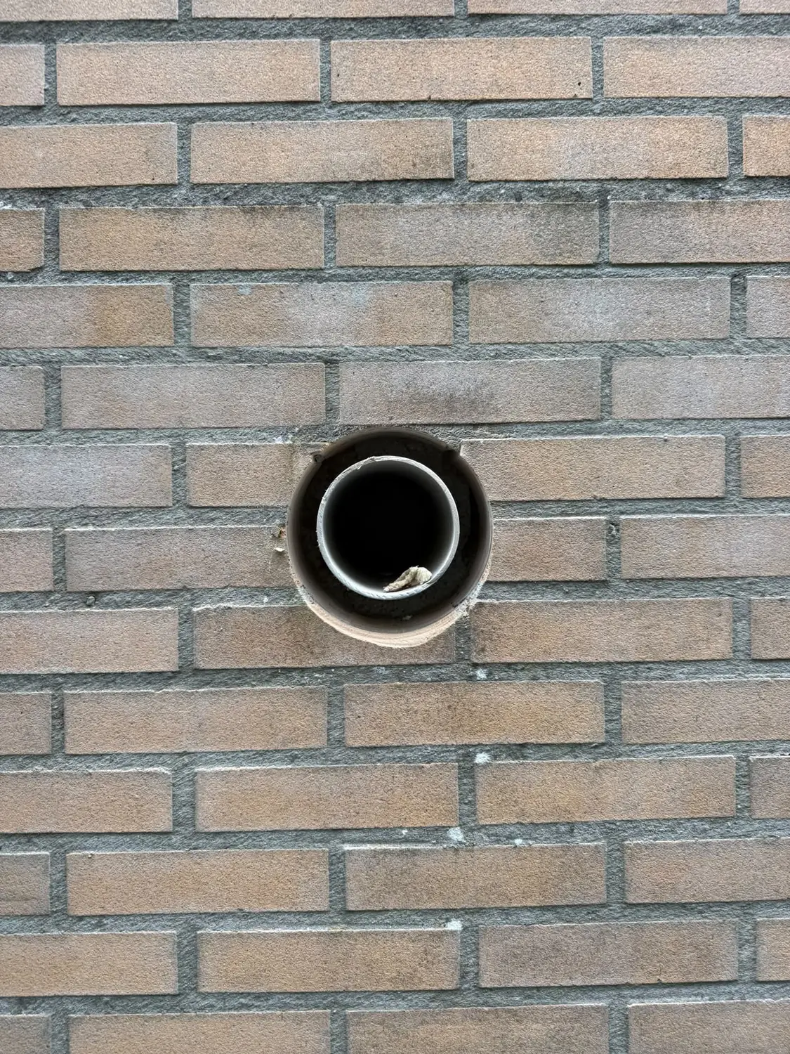 Strak afgewerkt 162 mm afzuigkap gat in bakstenen buitenmuur na overboren — Eindhoven