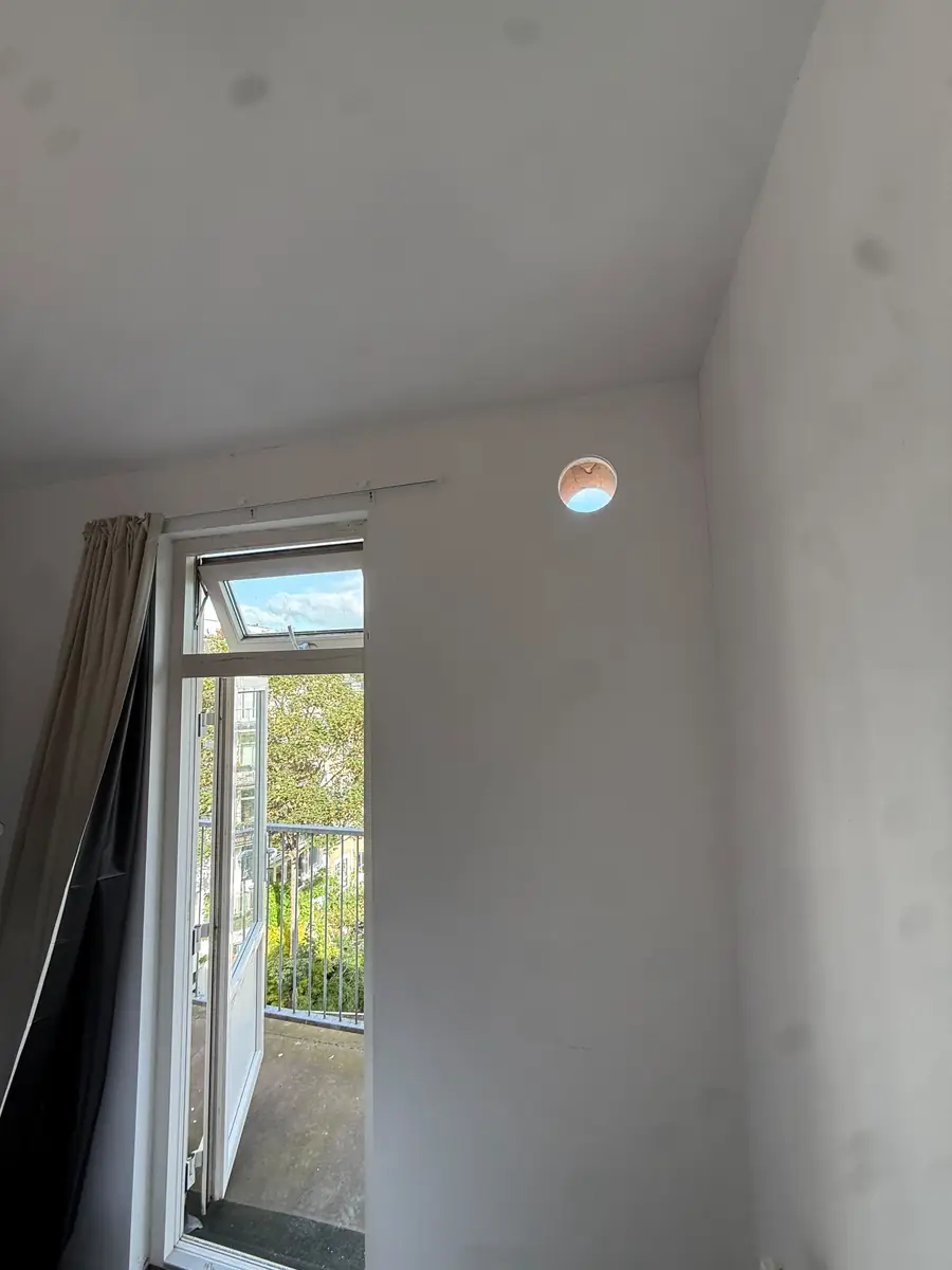 Afzuigkap gat boren Amsterdam &mdash; Afzuigkapgat hoog in de wand van een appartement, naast de balkondeur