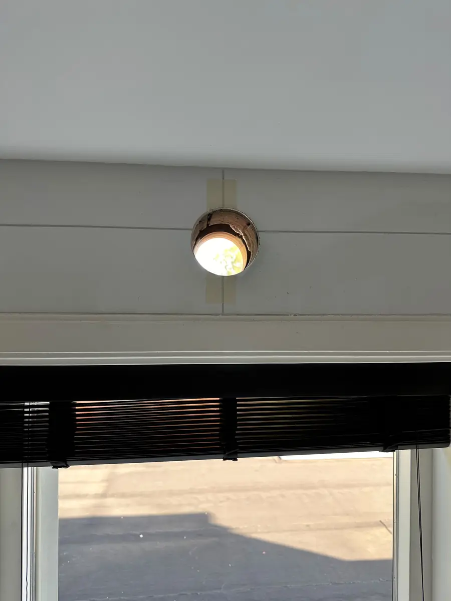 Afzuigkap gat boren Oosterhout &mdash; Afzuigkapgat boven een raam met jaloezie&euml;n, in een witte wand met afplaktape