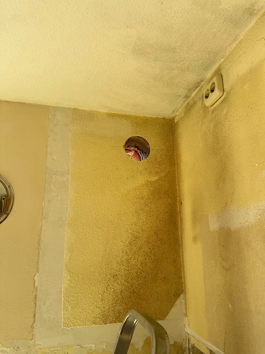 Afzuigkap gat boren Maashorst &mdash; Afzuigkapgat hoog in de hoek van een gele keukenwand, vlak onder het plafond