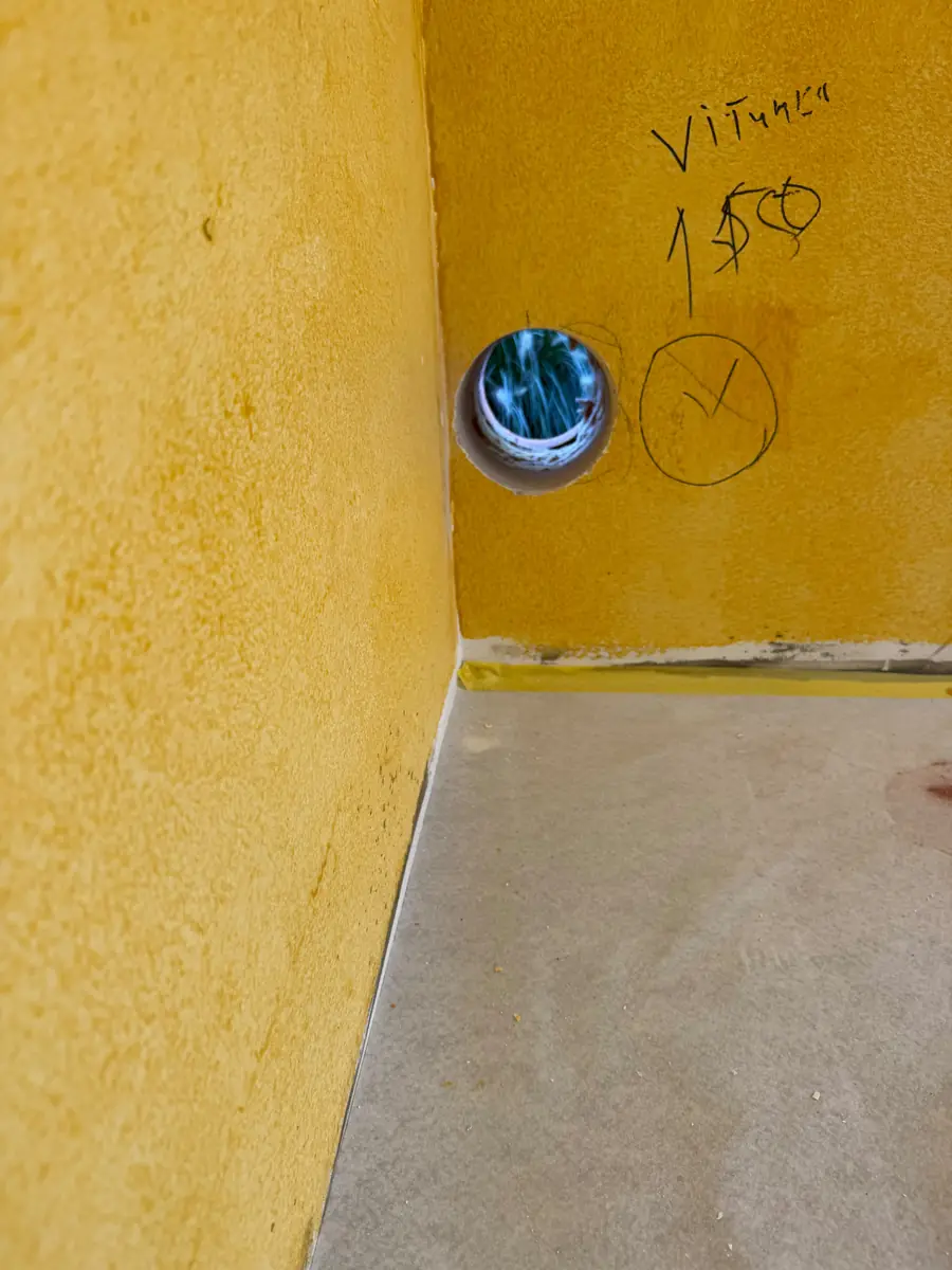 Afzuigkap gat boren Maashorst &mdash; Afzuigkapgat in een gele wand, met de maat 150 en de plek met stift op de muur gemarkeerd