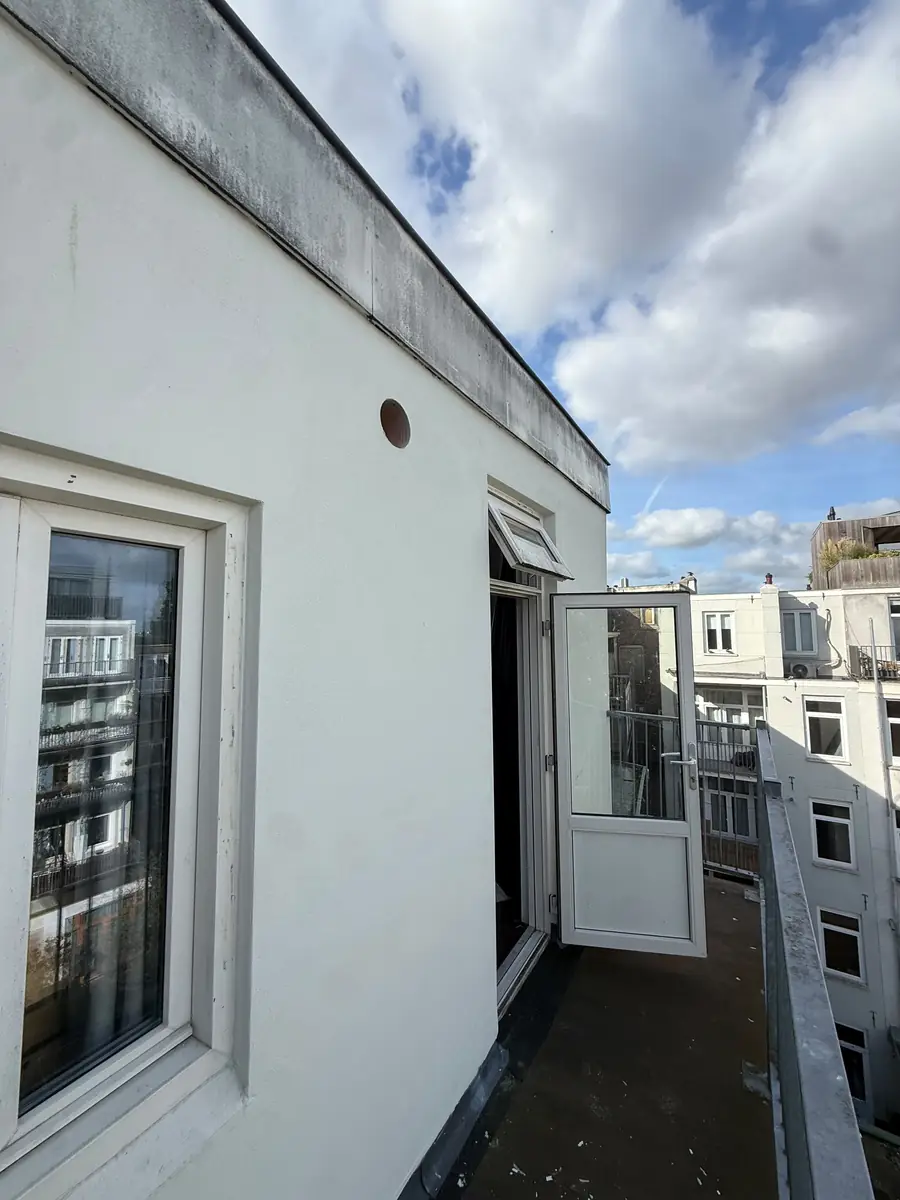 Afzuigkap gat boren Amsterdam &mdash; Afzuigkapgat van buiten gezien, hoog in de witte gevel van een dakappartement