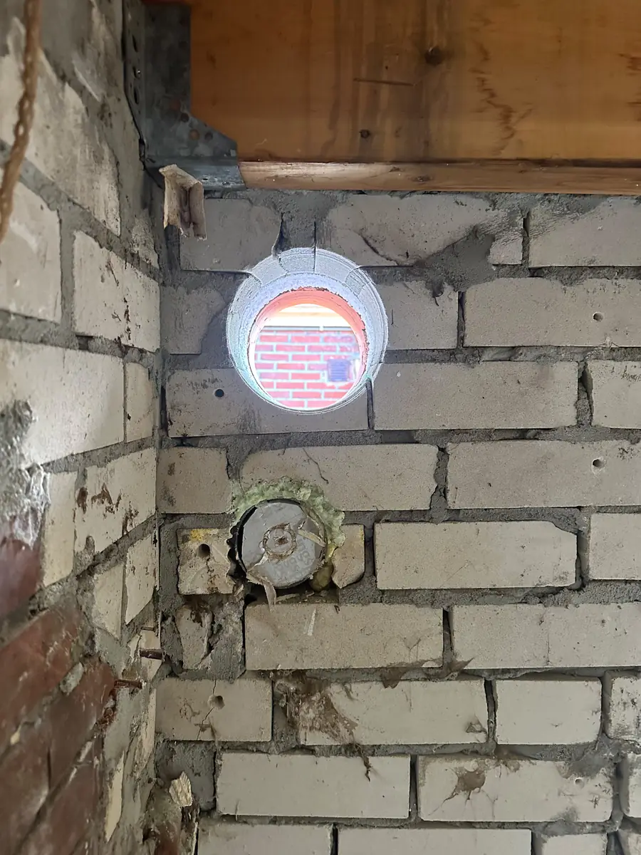 Afzuigkap gat boren Meierijstad &mdash; Afzuigkapgat door een binnenmuur van kalkzandsteen, met door het gat een rode bakstenen muur buiten