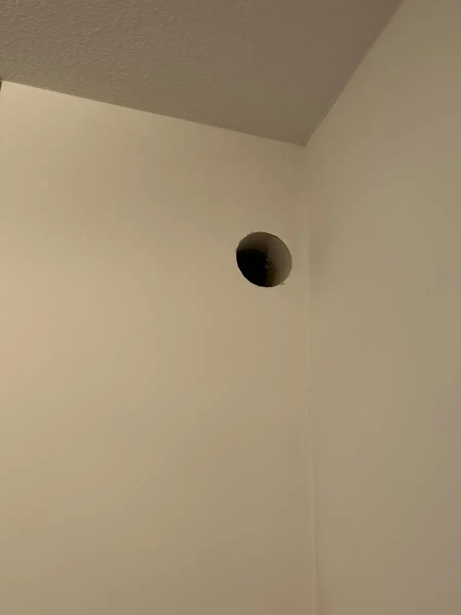 Afzuigkap gat boren Brunssum &mdash; Afzuigkapgat in de hoek van een lichte keukenwand, vlak onder het plafond