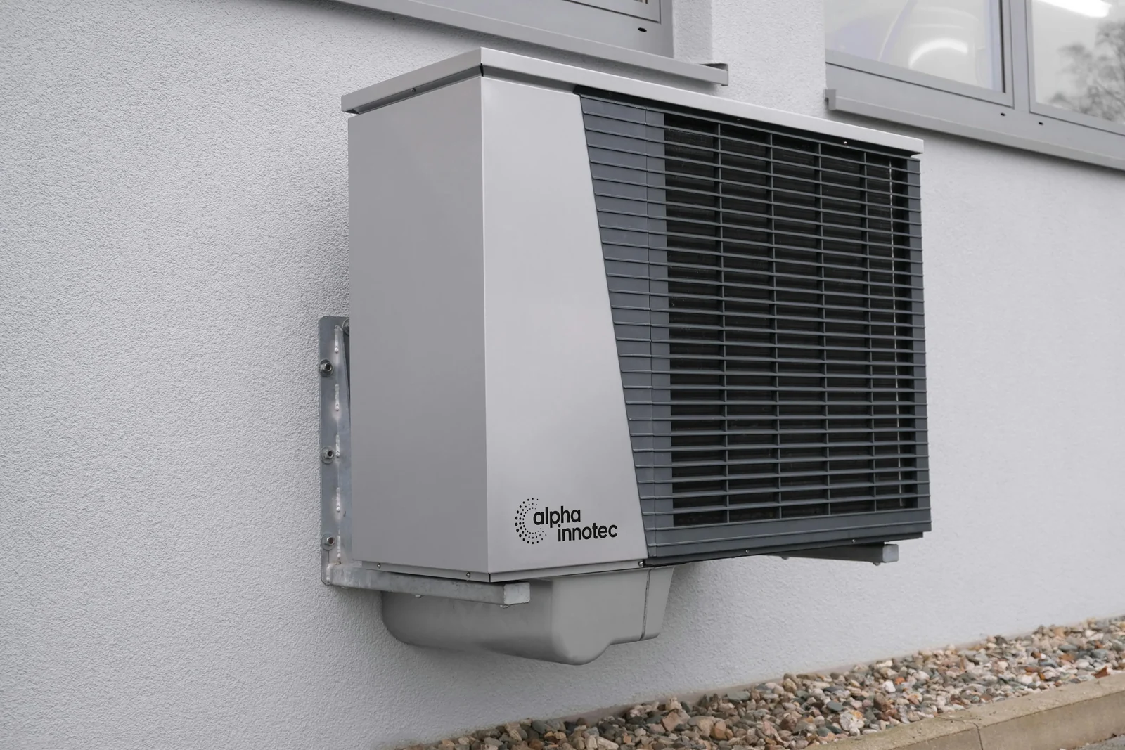 Buitenunit van een warmtepomp aan de gevel