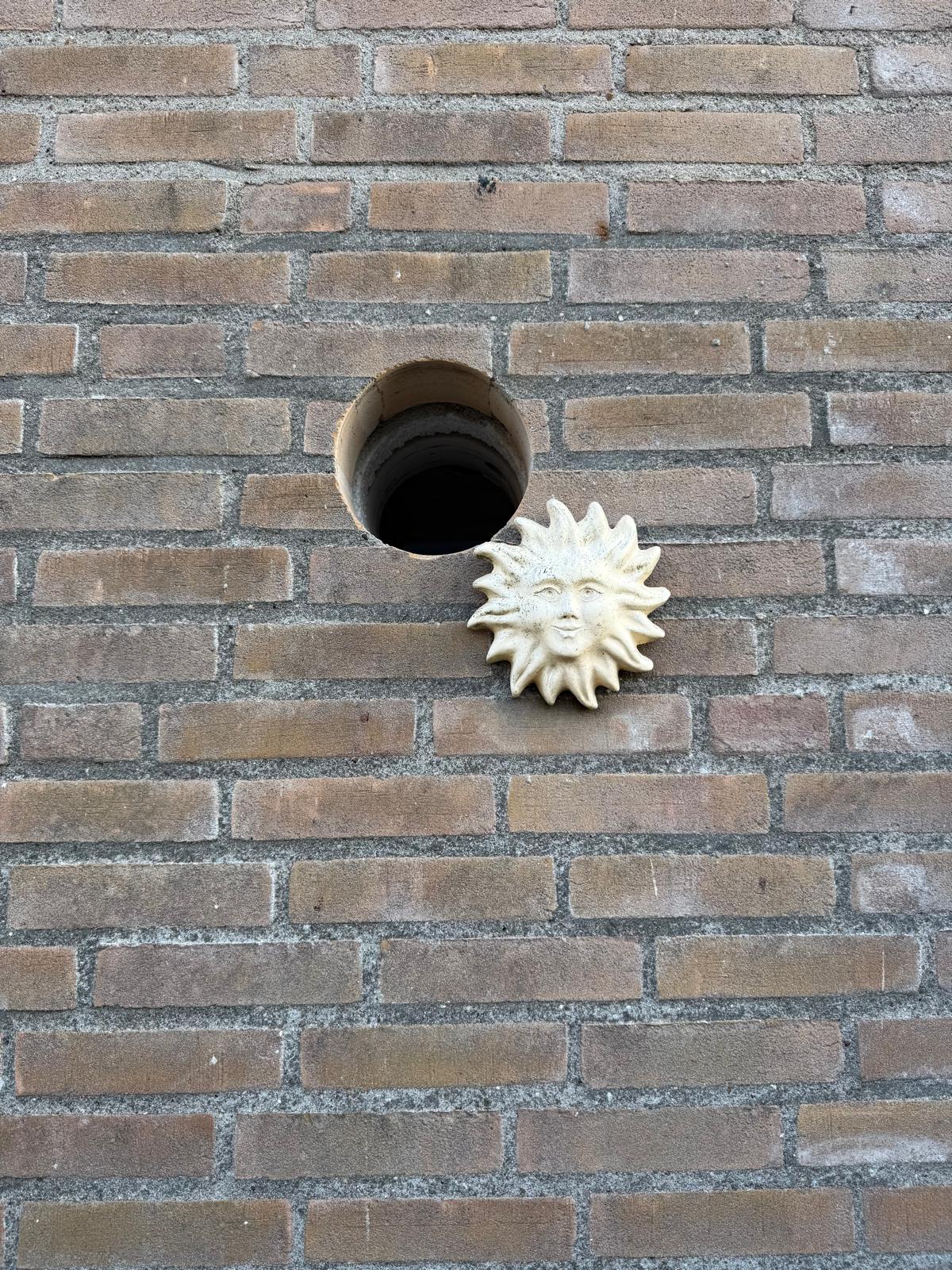 Boorgat in bakstenen gevel particuliere woning
