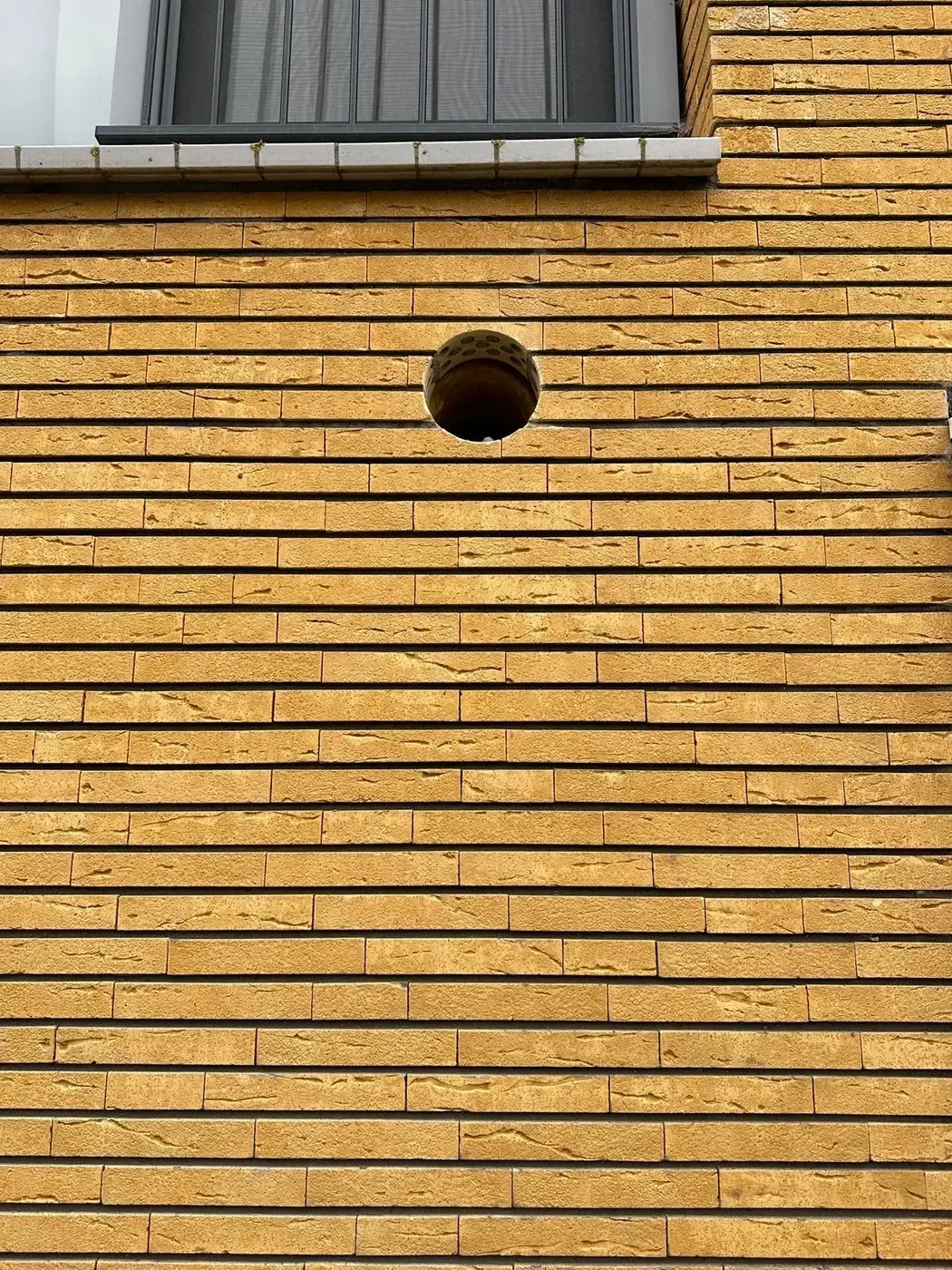 Kernboring in gele bakstenen buitengevel