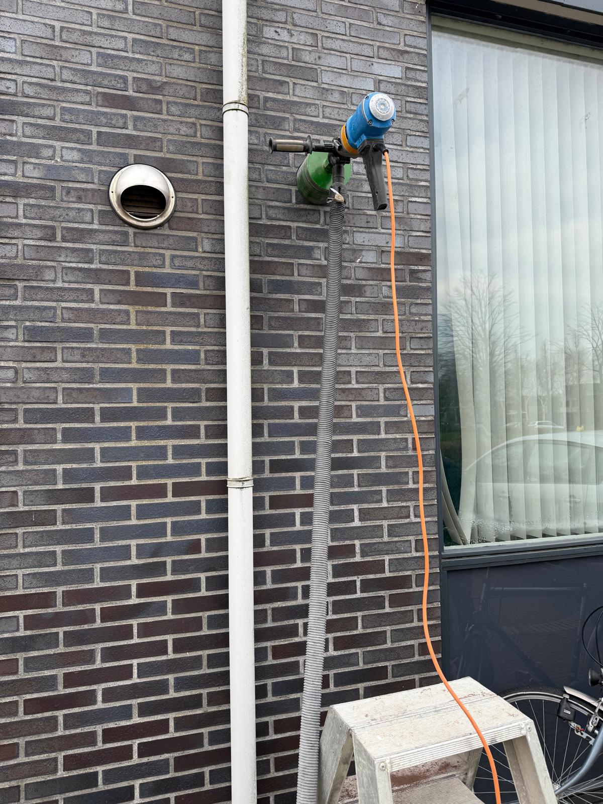 Gat boren voor buitenkraan in buitenmuur — Boorkoning