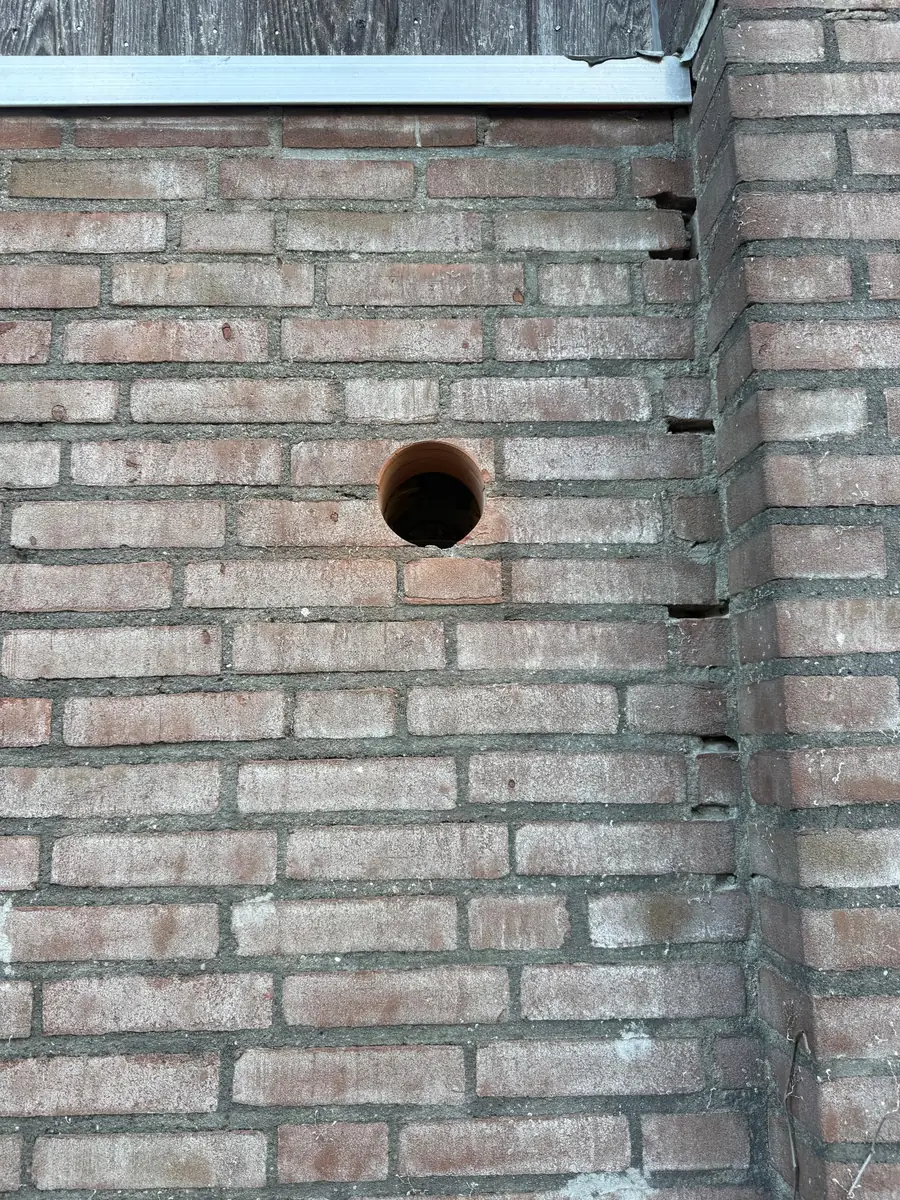 Betonboringen Bergeijk &mdash; ronde doorvoer in lichte baksteen, onder de afdekker