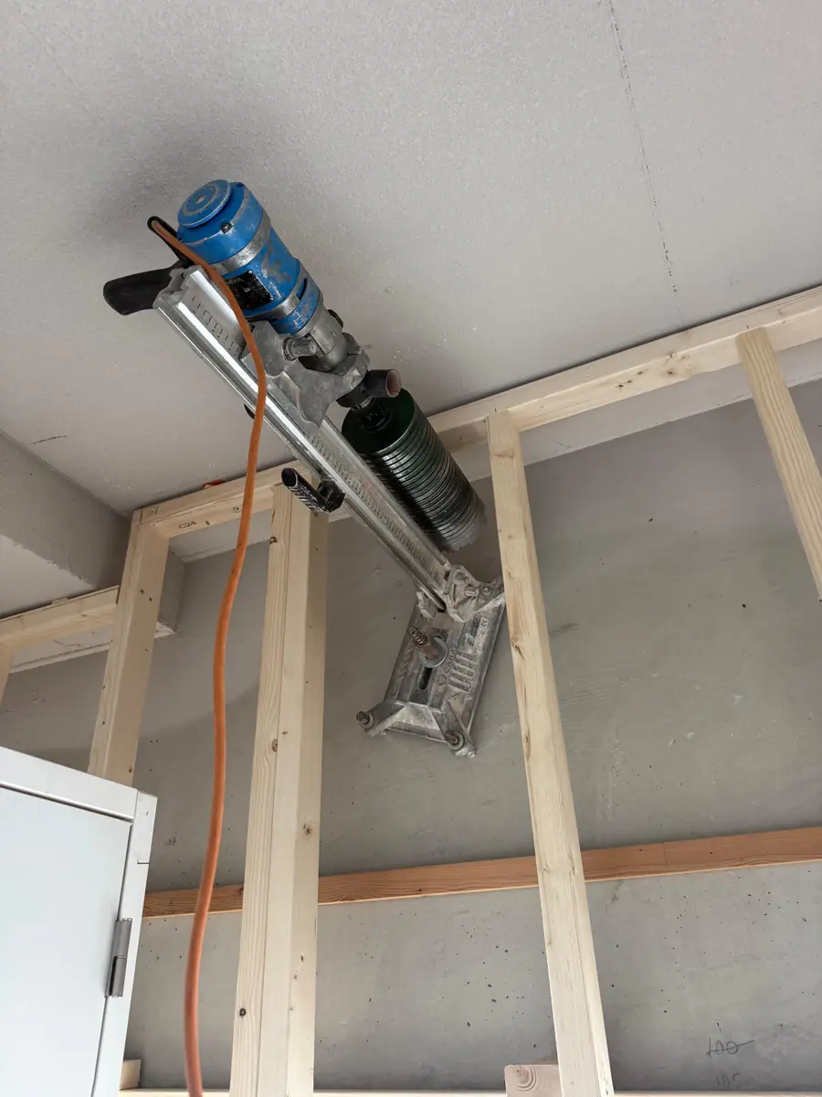 Betonboringen Bernheze &mdash; boormachine op een statief boort omhoog tussen nieuw houten regelwerk