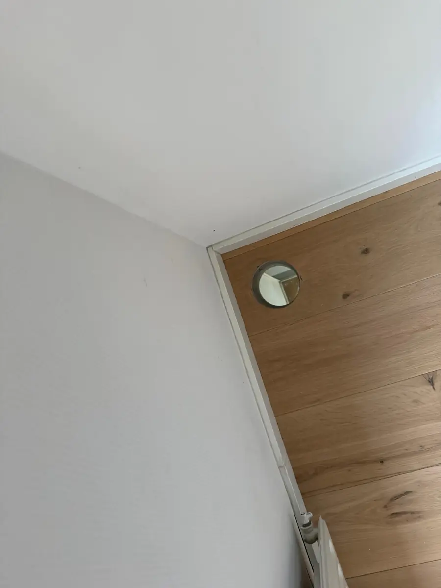 Betonboringen Boekel &mdash; ronde doorvoer door een houten wandbekleding, vlak bij de hoek