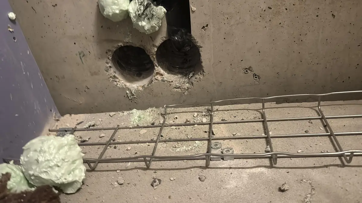 Betonboringen Sint-Michielsgestel &mdash; twee grote boringen in een betonwand, met een wapeningsnet op de vloer
