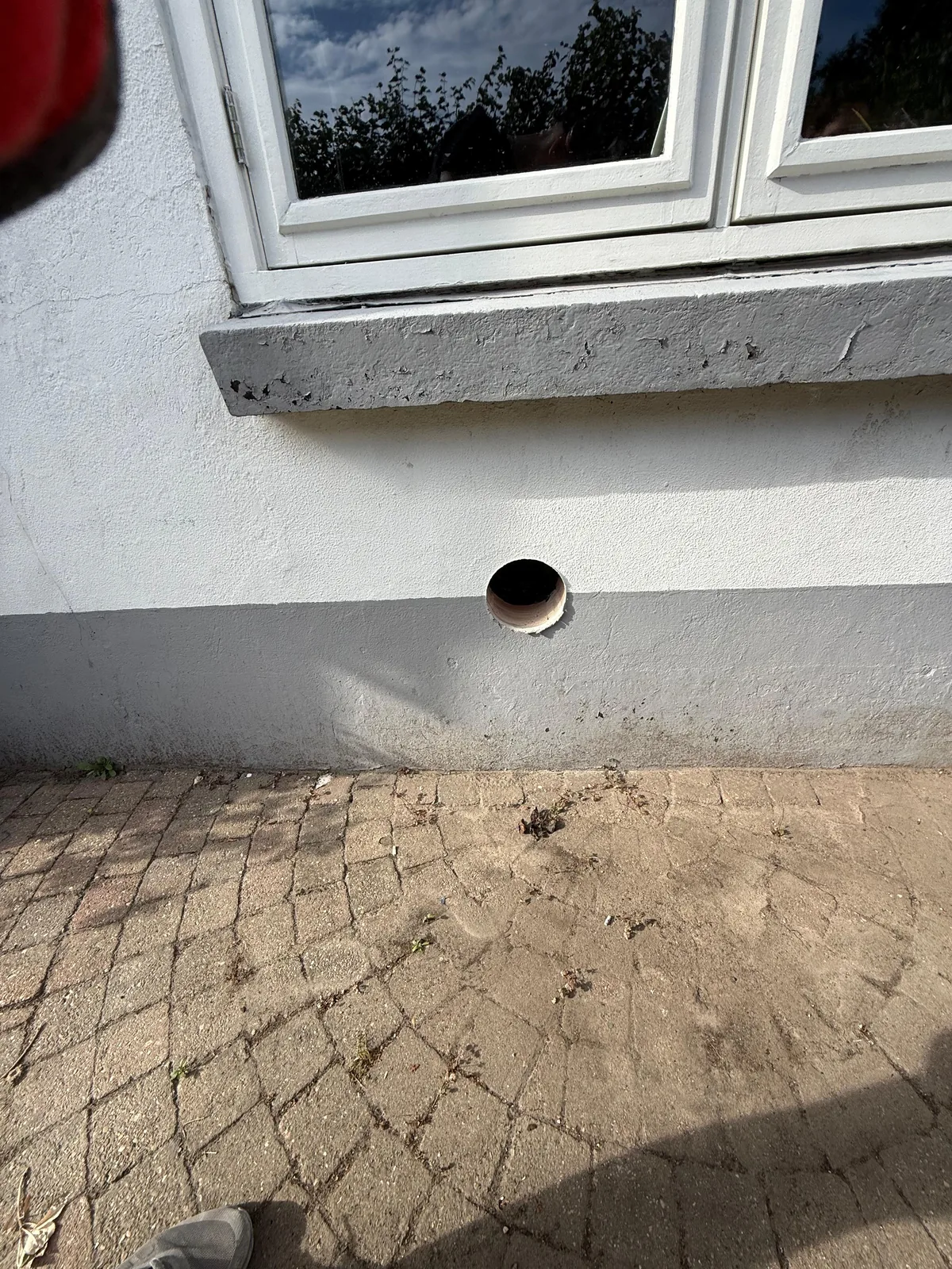 Nette ronde Bora-doorvoer in de gepleisterde buitenmuur, klaar voor het buitenrooster — Den Bosch