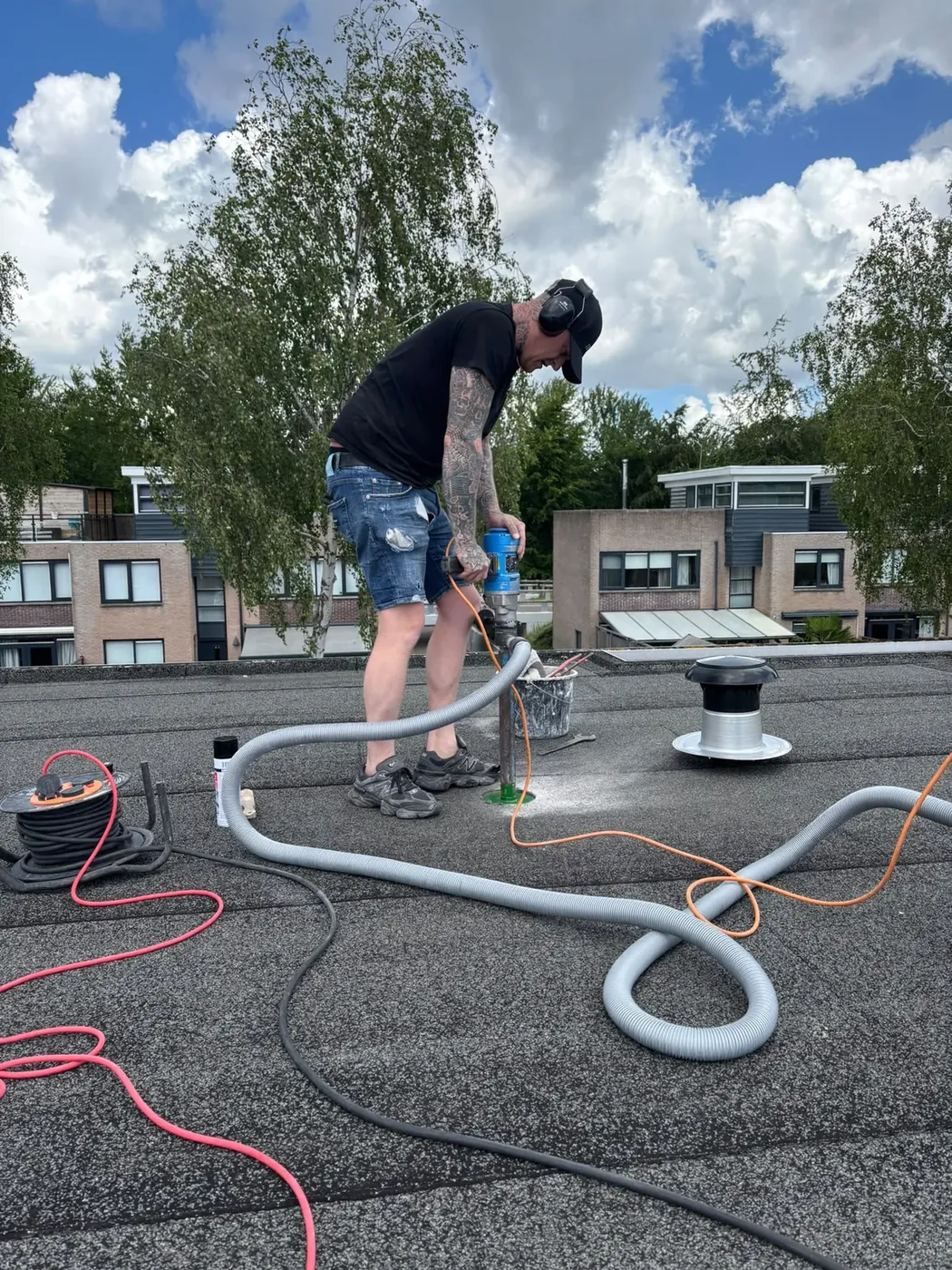 Dakdoorvoer boren op plat dak — kernboor in actie met stofafzuiging