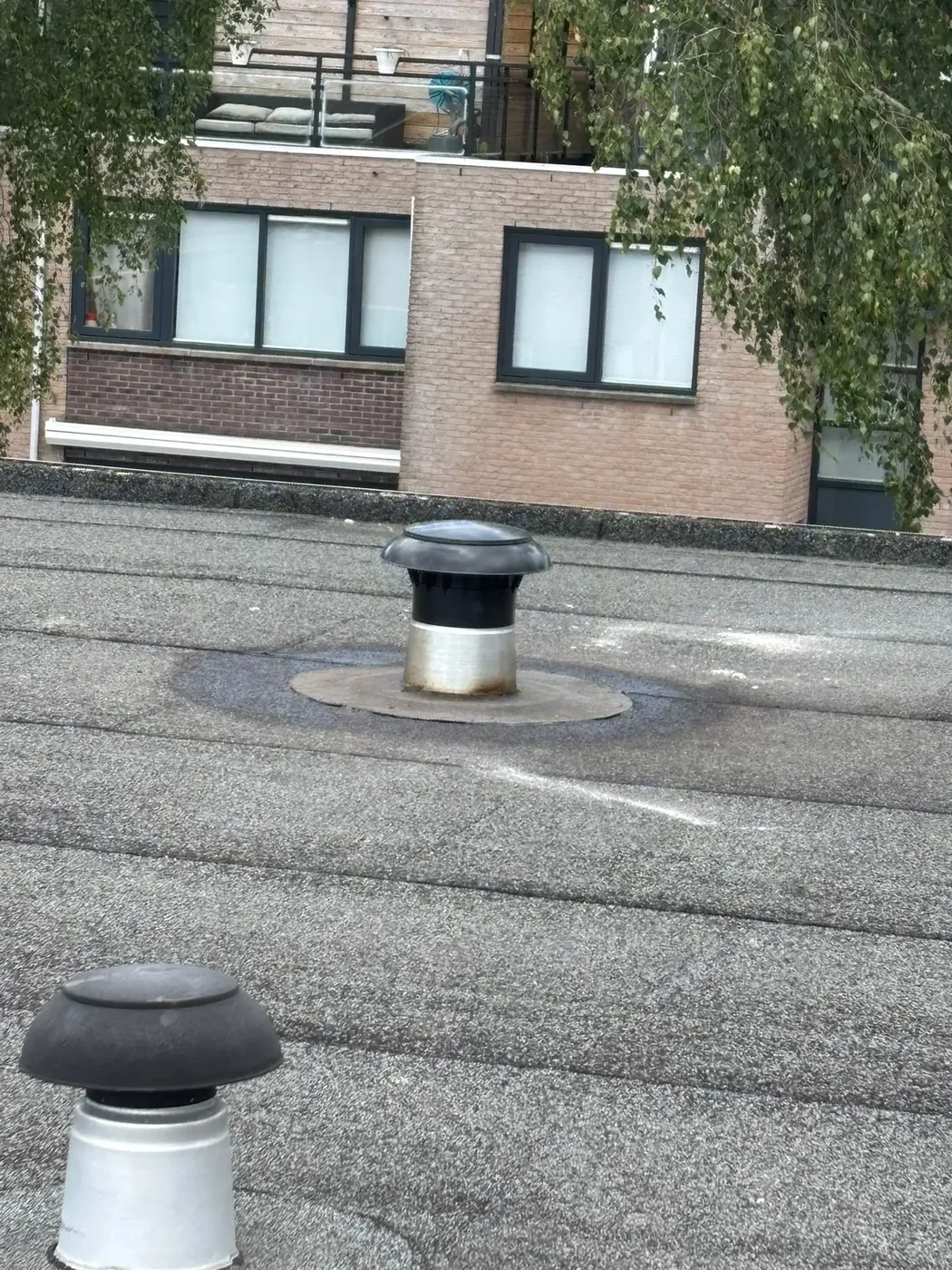 Twee afgewerkte ventilatiedoorvoeren op plat dak