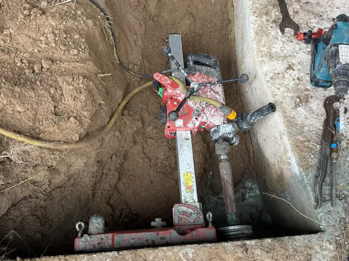 Hilti DD-150U op een boorstatief in een handgegraven put, klaar om door de funderingsbalk te boren bij Plaza Padel Helmond