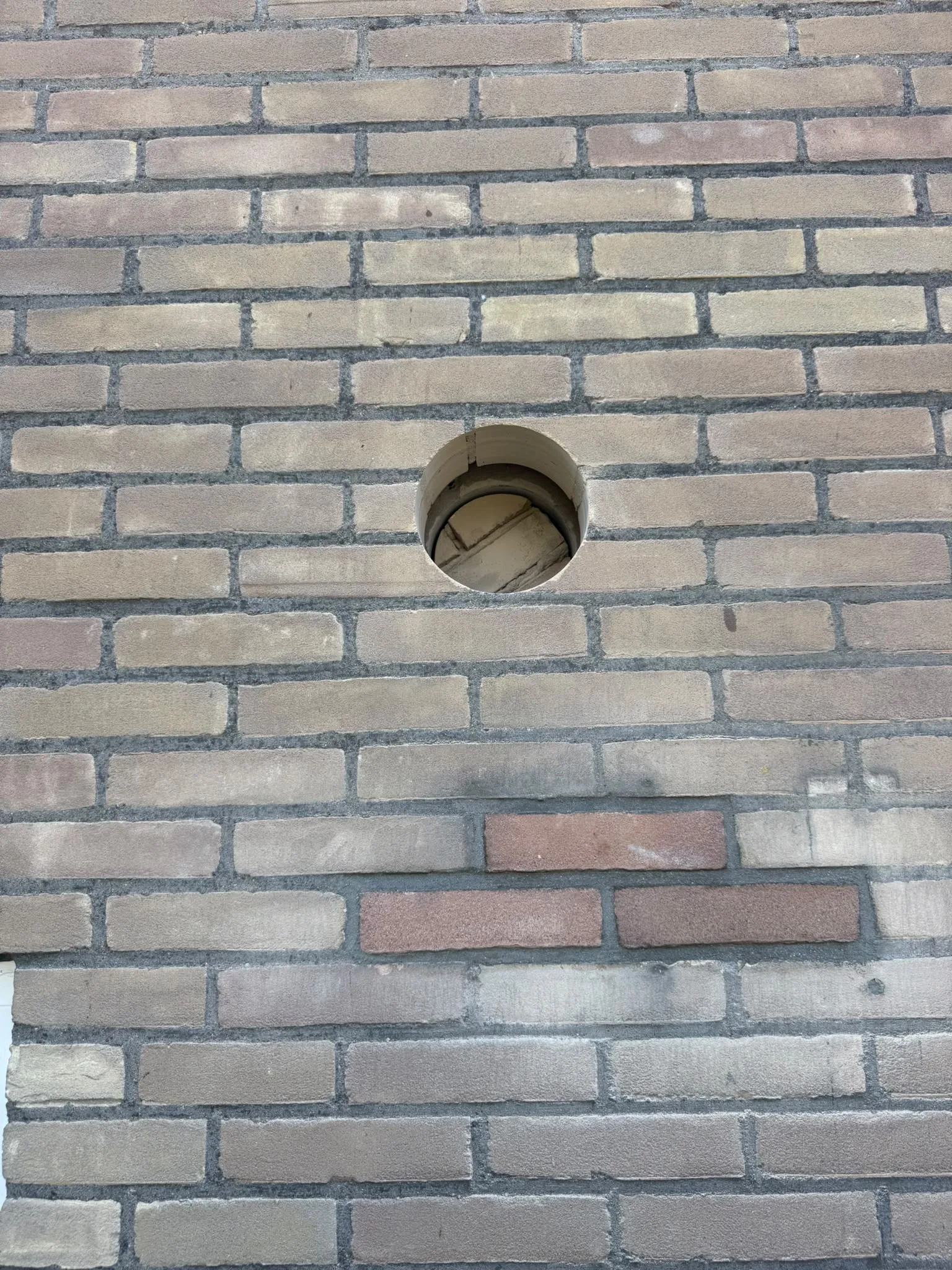 Gat boren spouwmuur — kernboring resultaat in baksteen buitenmuur Brabant Limburg