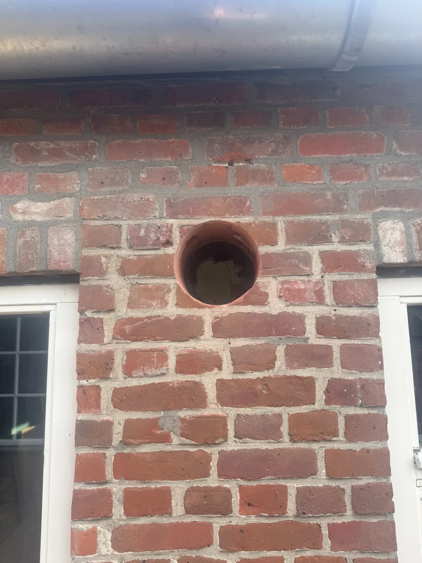 Kernboring met diamantboor door volsteens baksteen gevel — close-up doorvoer Weert