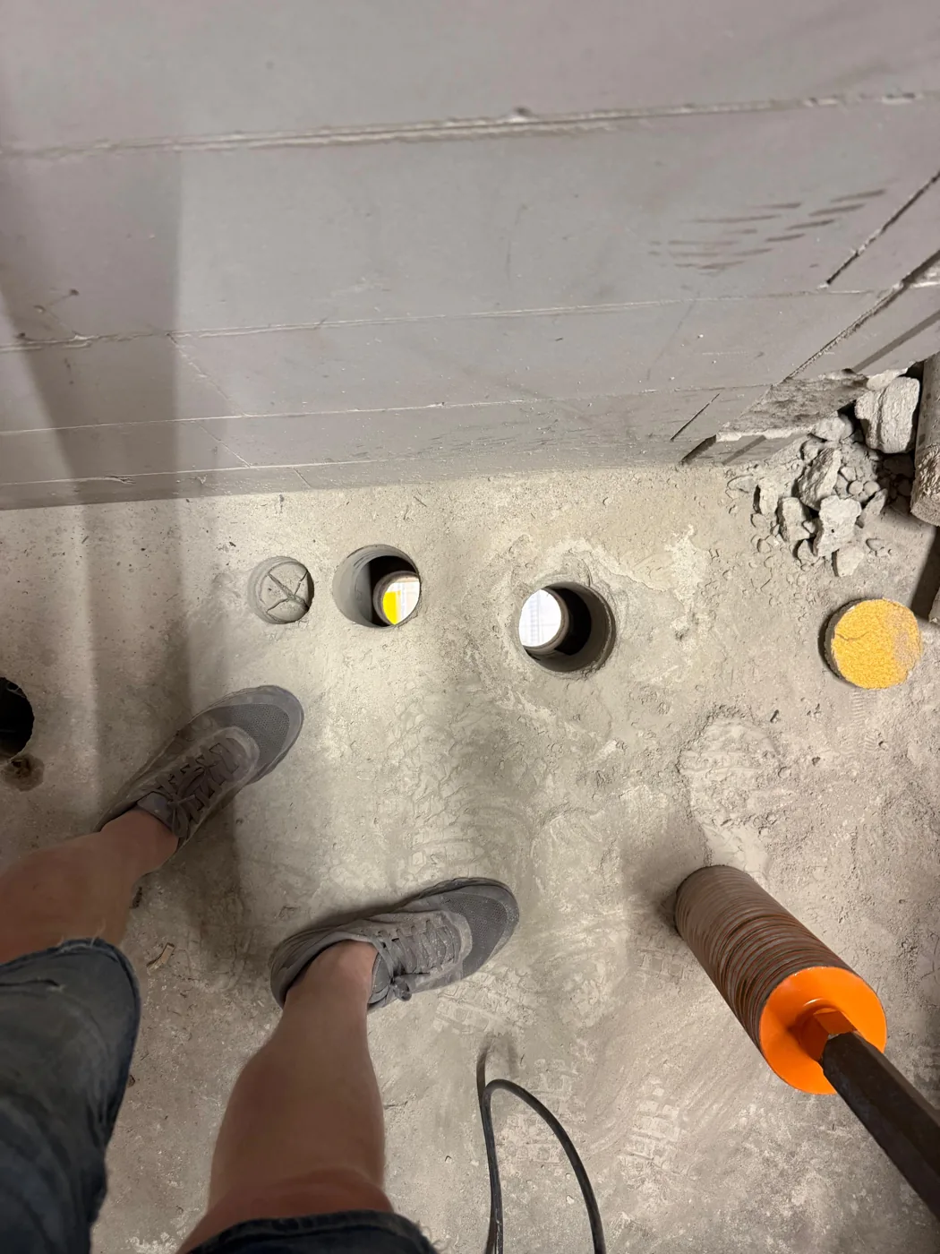 Ronde 110 mm kanaalplaatboring strak door de betonvloer geboord in een winkelpand in Breda, met doorkijk naar de verdieping eronder