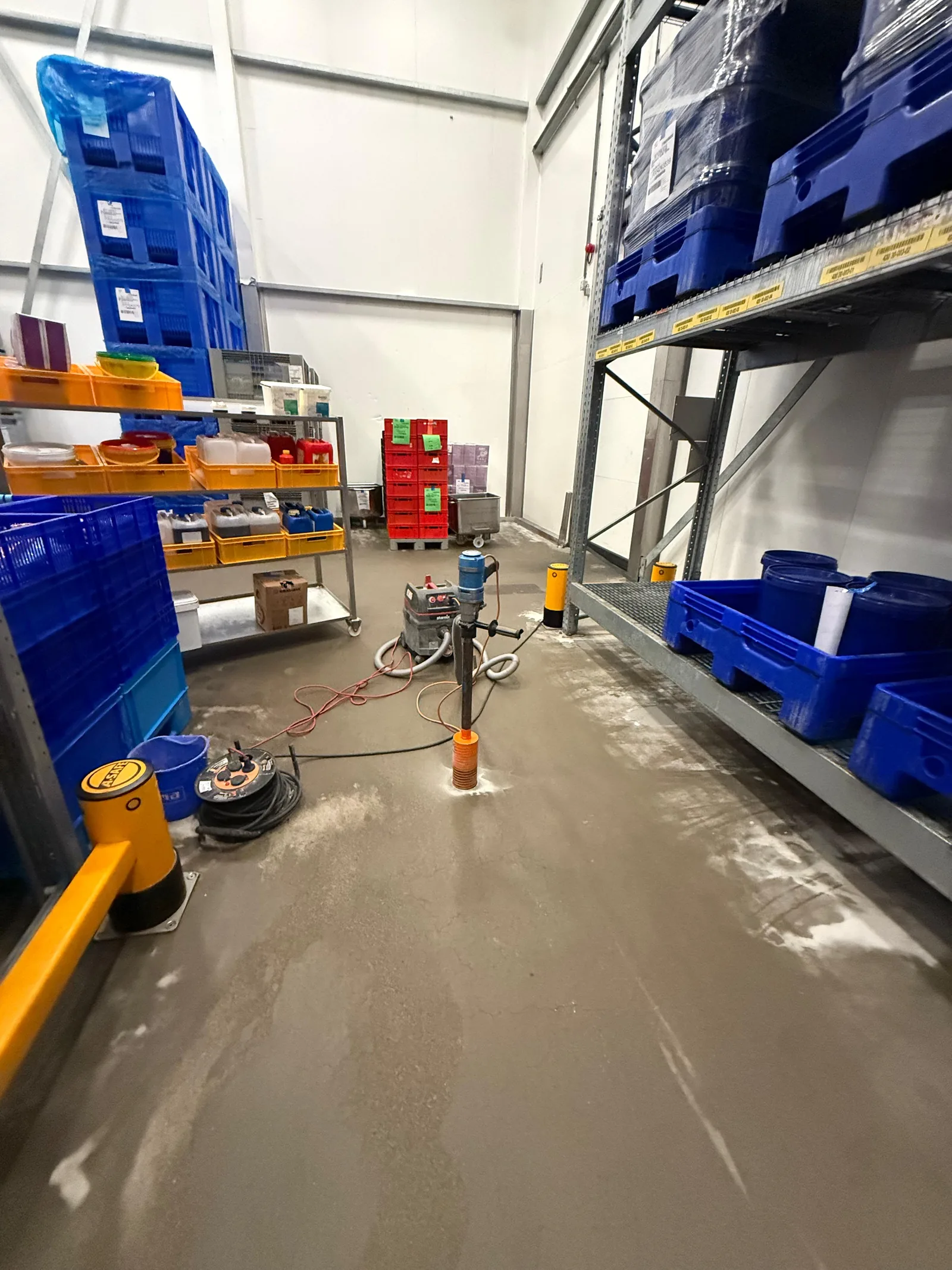 Kernboring in de koelcel van Bonfait tussen de stellingen, met boorstof rond het boorgat