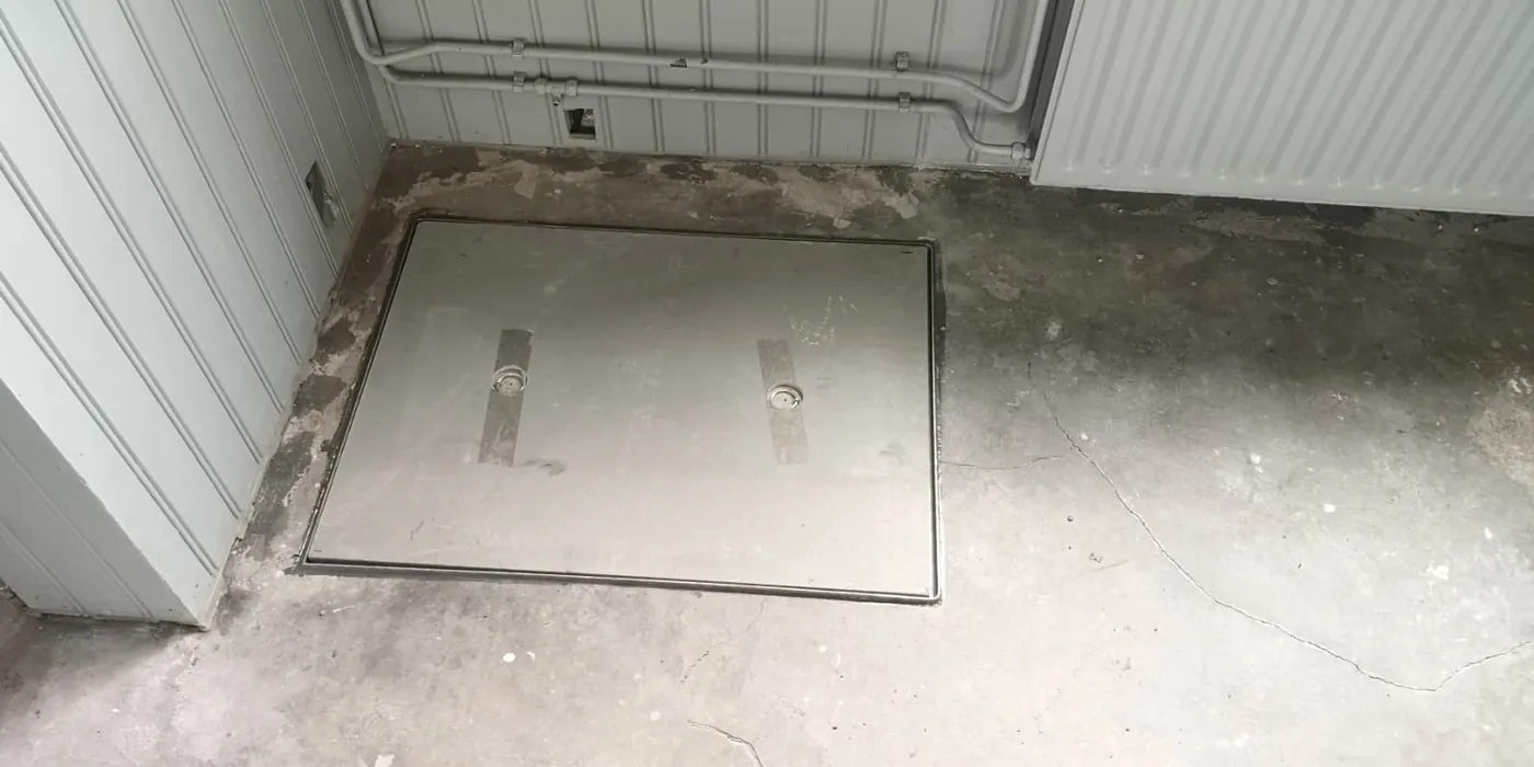 Afgewerkt kruipluik op maat in Tilburg &mdash; metalen luik vlak in de betonvloer met verzonken handgrepen