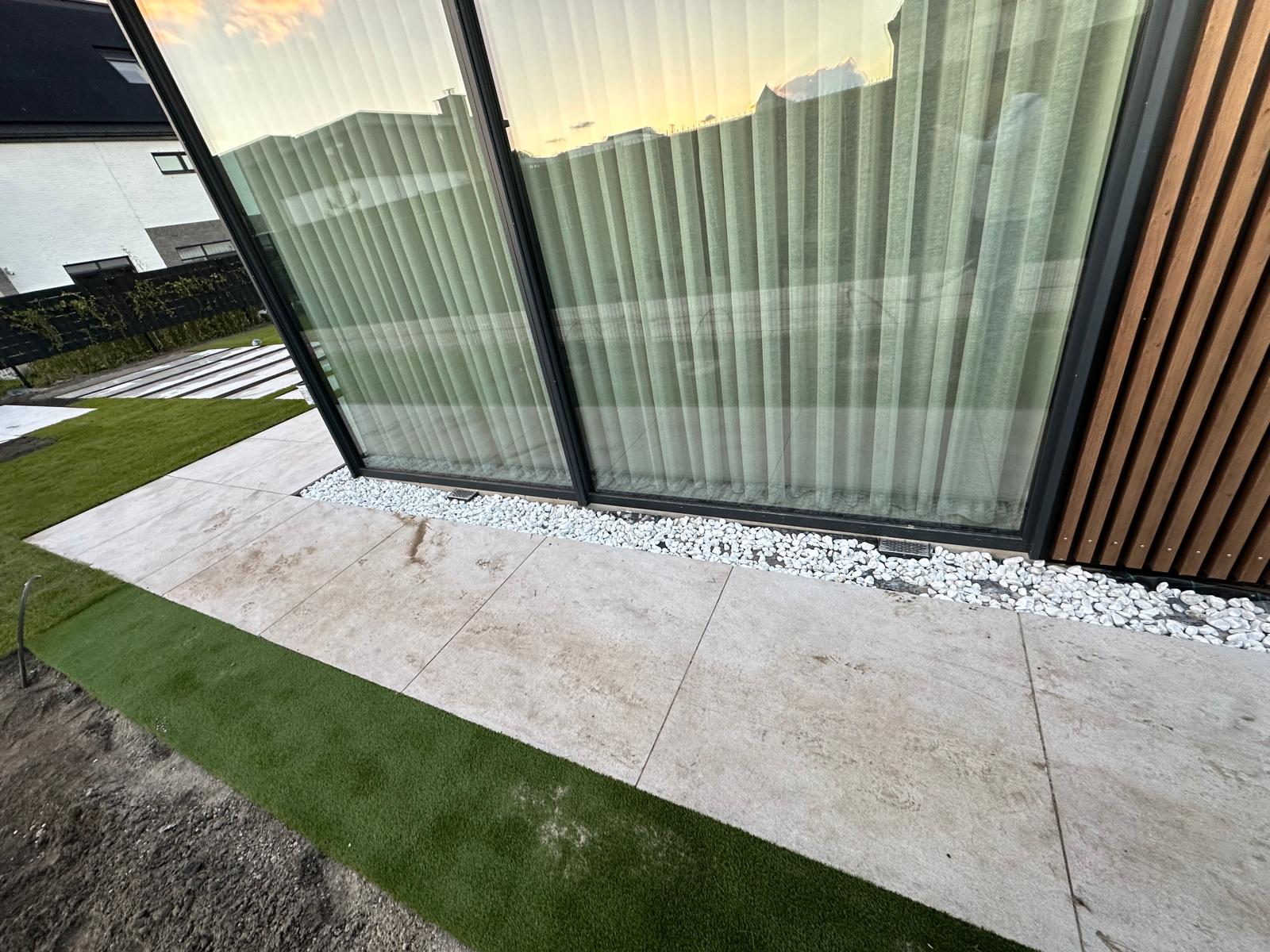 Kruipruimte ventilatie bij moderne woning met schuifpui en witte grindstrook