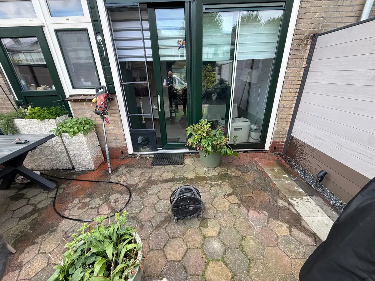 Kruipruimte ventilatie Veldhoven &mdash; Achtergevel met tuindeuren en ventilatieroosters, op een terras van zeshoekige tegels