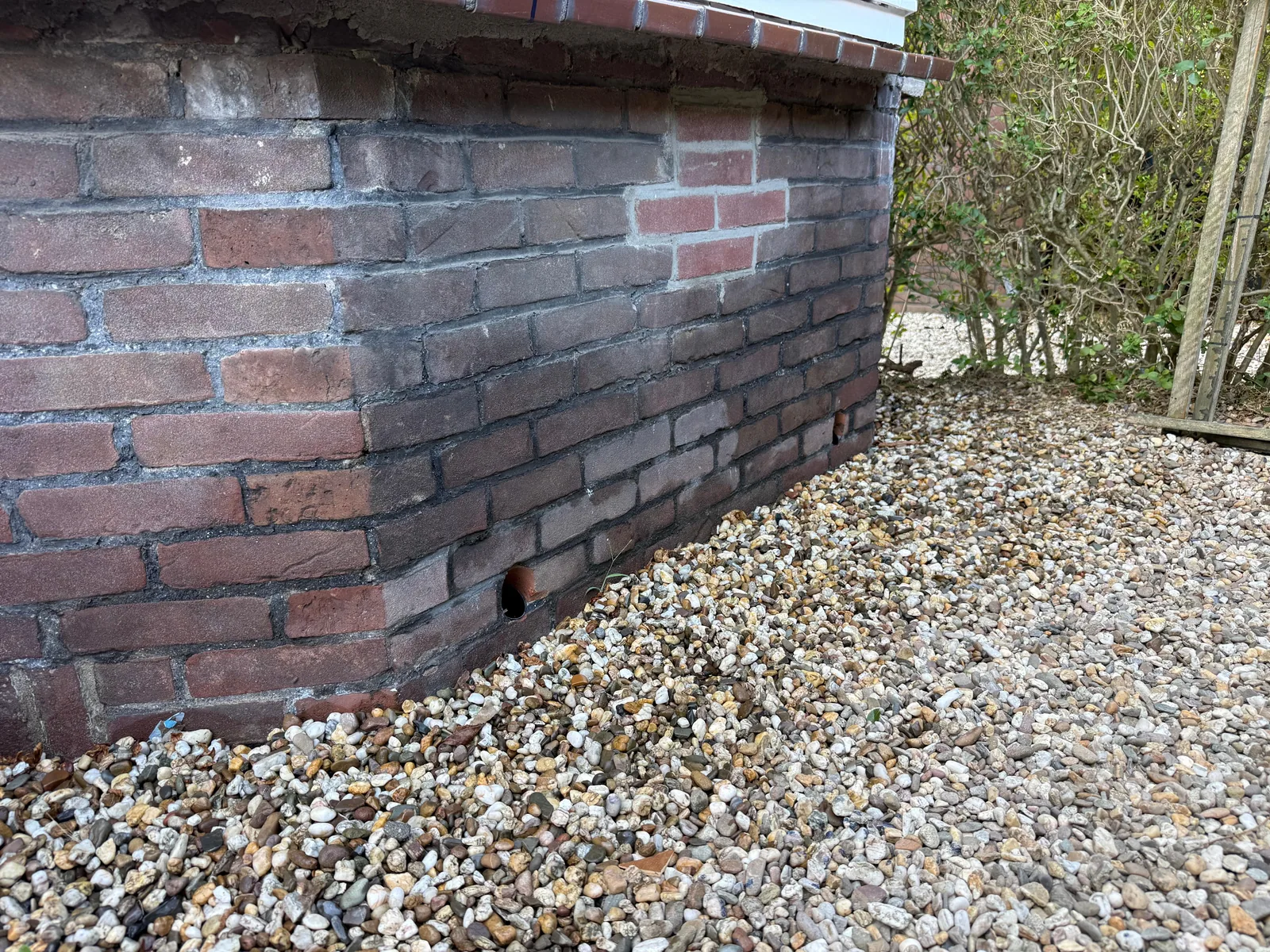 Schuin geboorde ventilatiedoorvoer laag in de bakstenen gevel voor de kruipruimte — Valkenswaard
