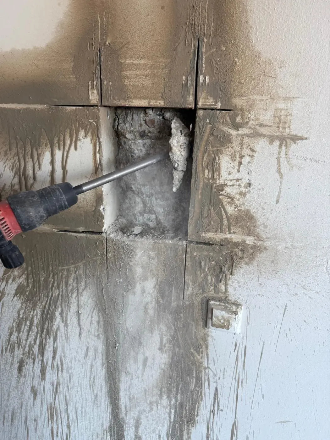Rode sloophamer breekt opening door betegelde muur actieshot