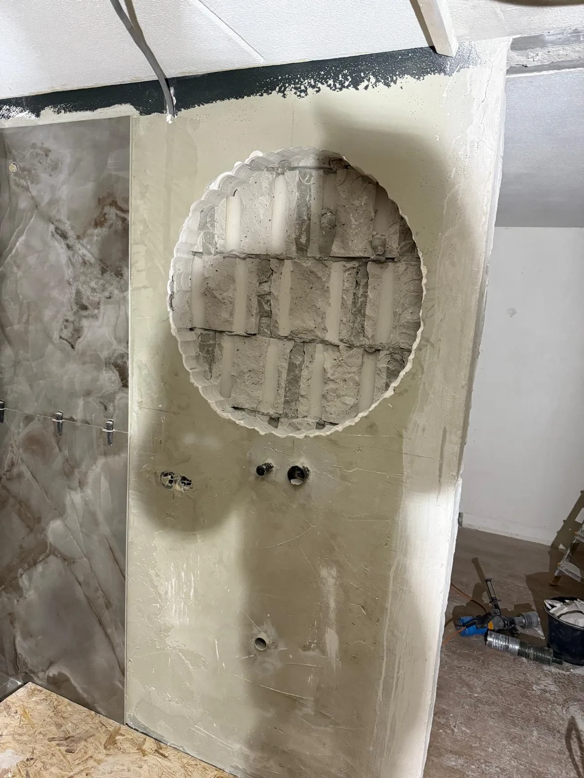 Grote ronde opening gemaakt in badkamerwand — precisie kernboring voor nis