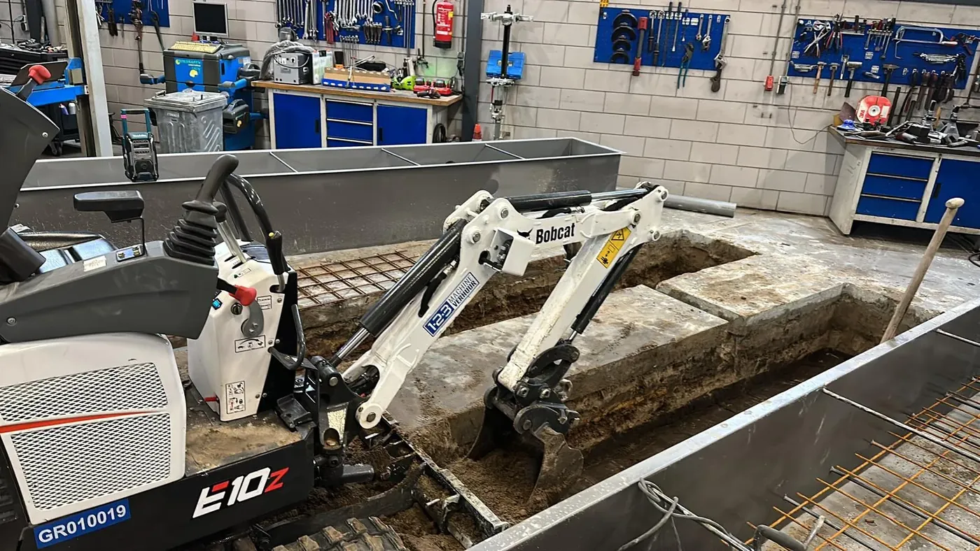 Bobcat E10z minigraver breekt betonvloer werkplaats — sleuven graven