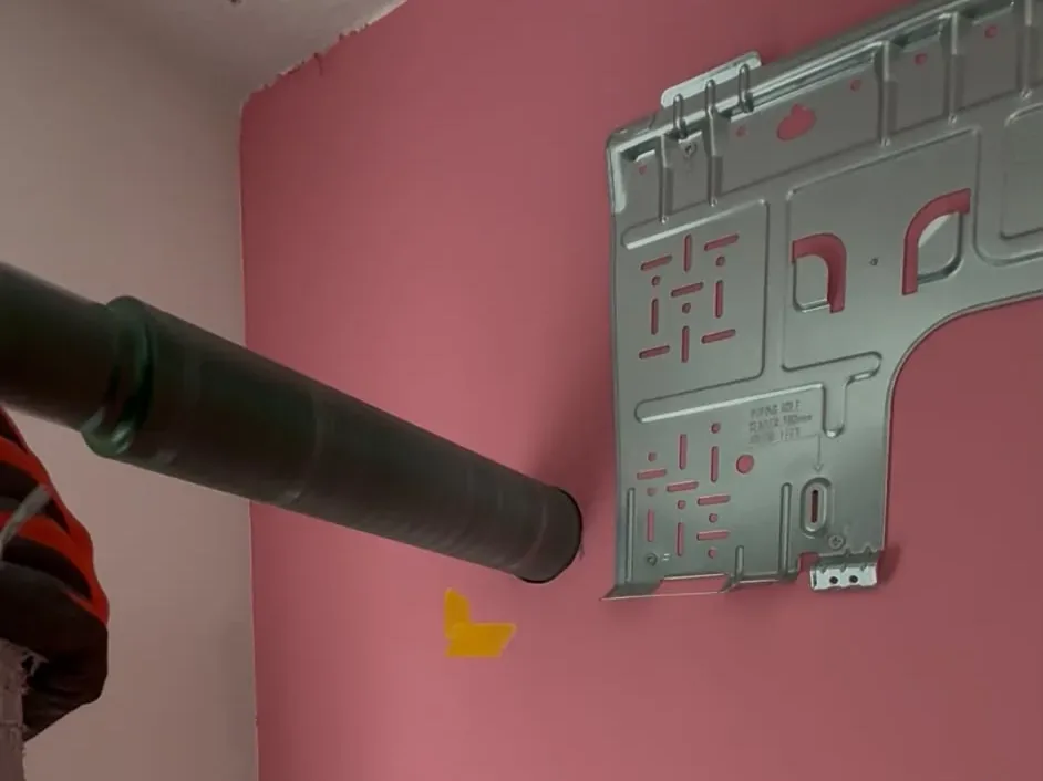 Kernboor in de muur naast de ophangplaat van de binnenunit van een split-airco