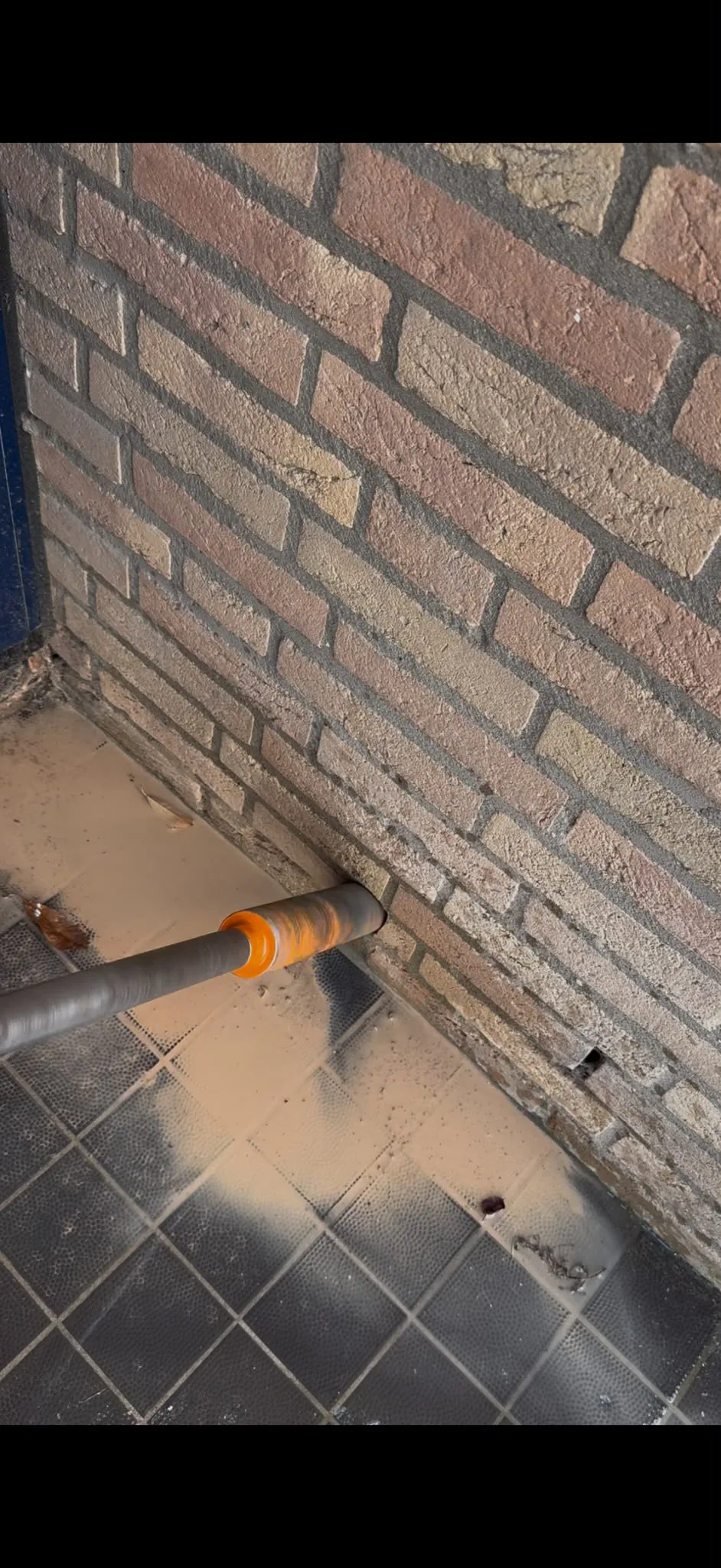 Boren ventilatiegaten kruipruimte — actie foto boor in baksteen fundering