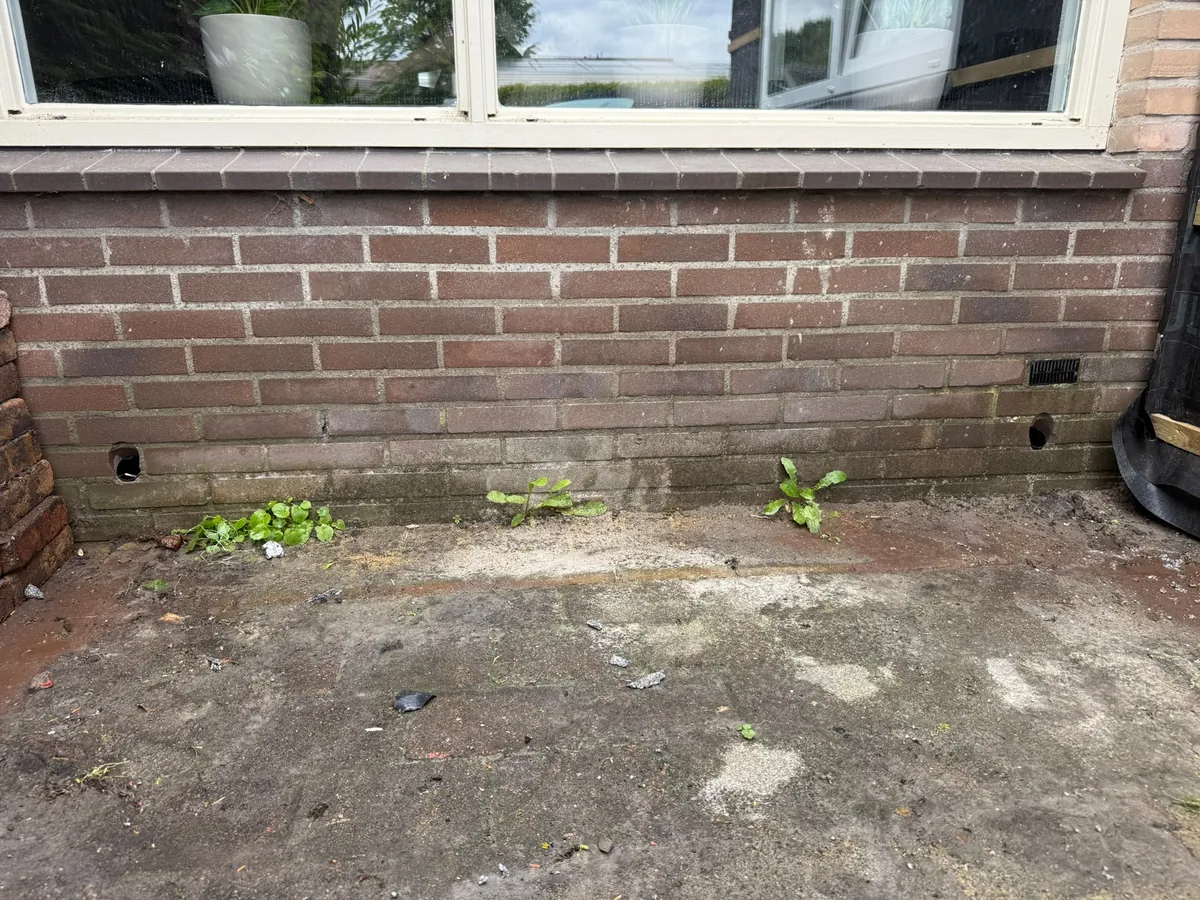 Ventilatiegaten geboord in baksteen fundering — voor plaatsing rooster