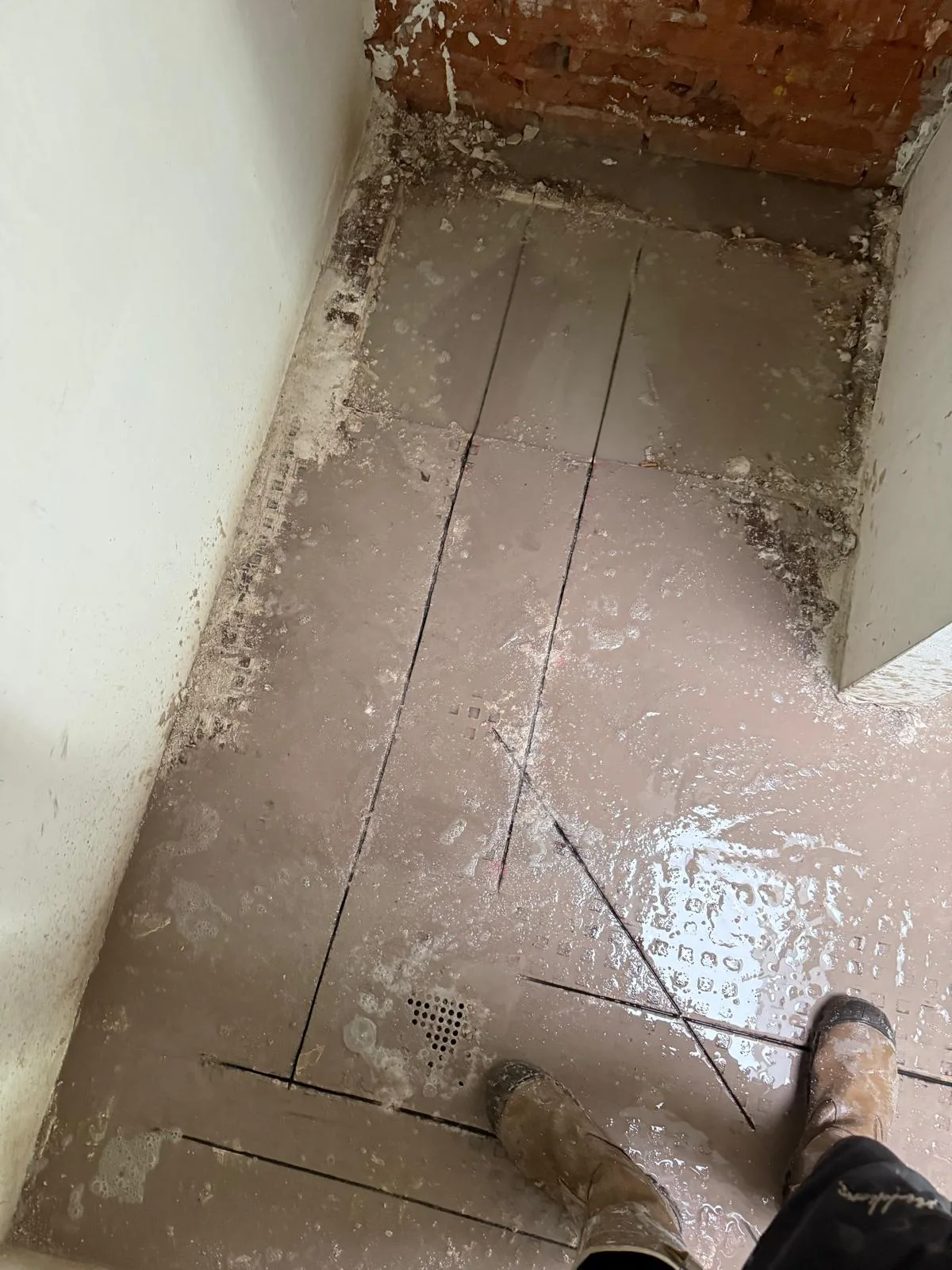 Zaagwerk in tegelvloer bij deuropening